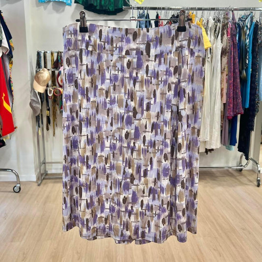 Abstract print midi skirt in purple, brown, and beige, displayed in a second hand fashion store