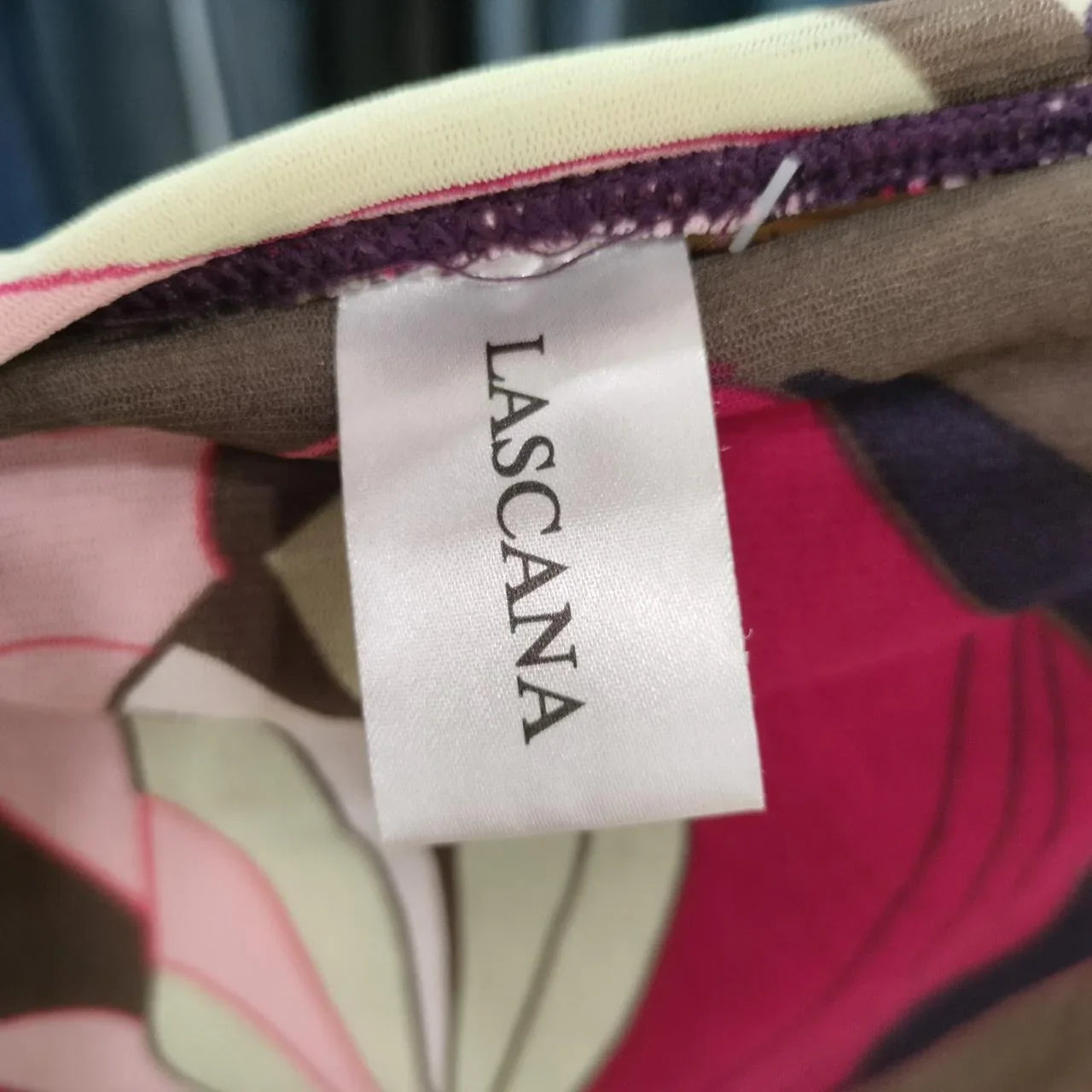 Close-up of LASCANA clothing label on floral patterned fabric, second hand fashion