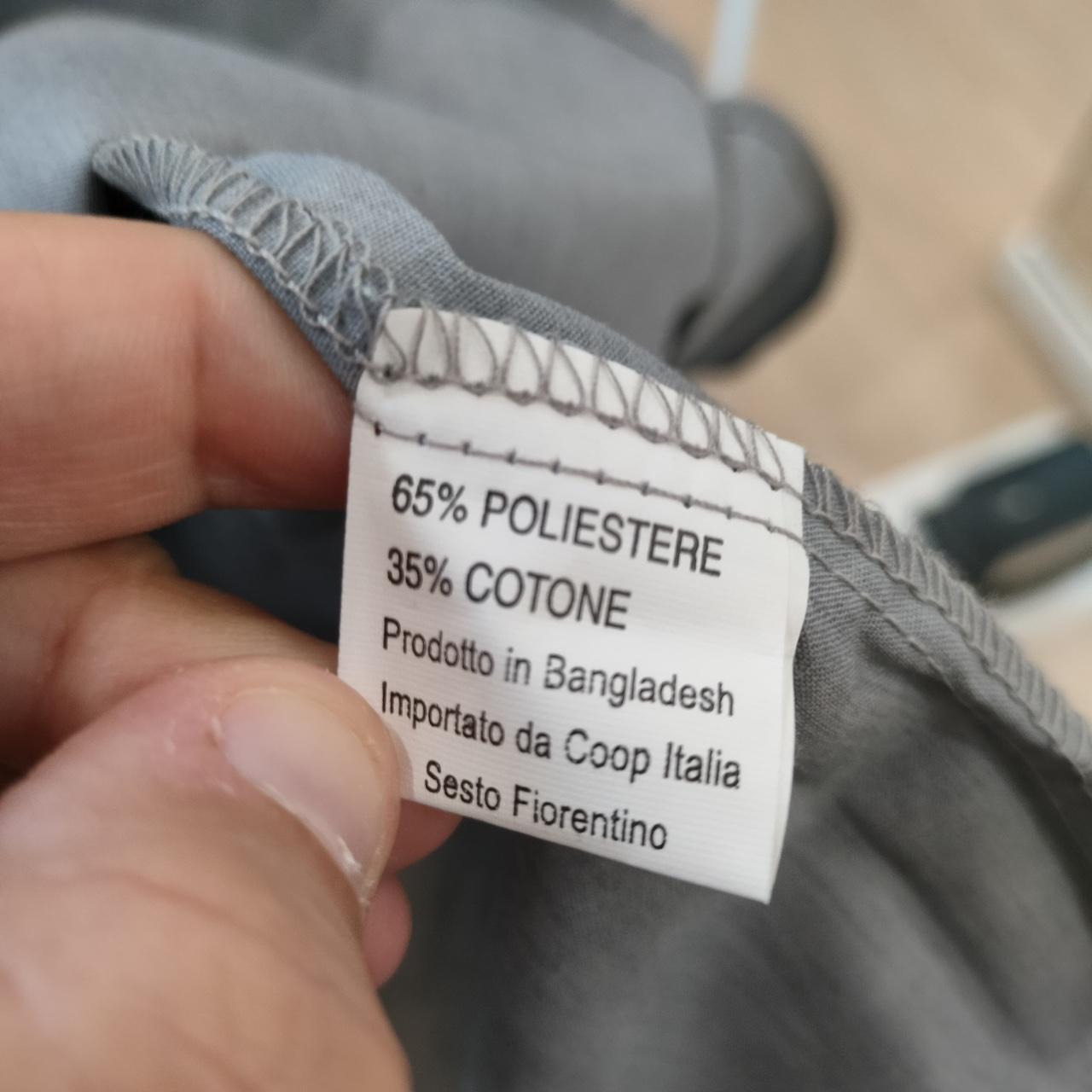 Fabric tag with material composition details held by a hand