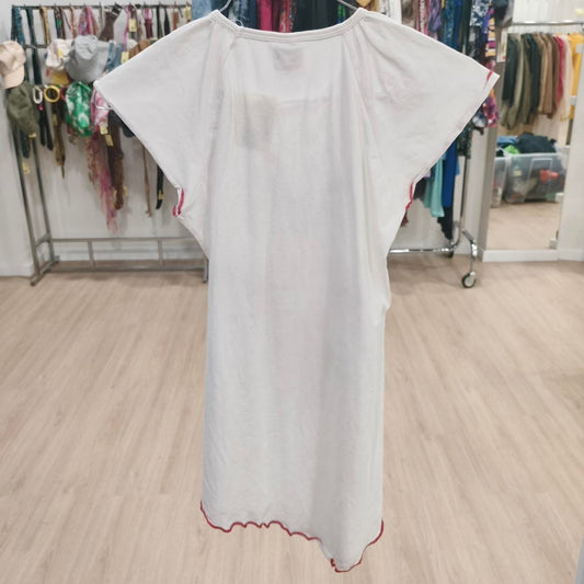 White short-sleeve dress with red trim on hanger in second hand clothing shop