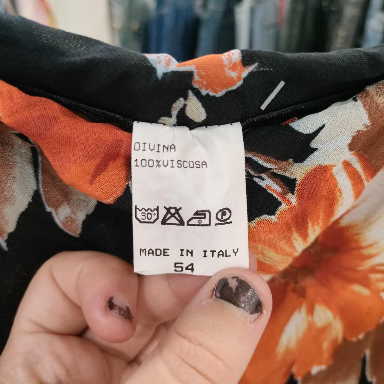 Close-up of care label on orange floral viscose clothing, made in Italy, size 54