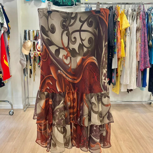 Brown and orange floral print tiered chiffon skirt hanging in a second hand clothing store