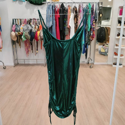 Green velvet slip dress with side drawstrings on display in a second hand fashion store