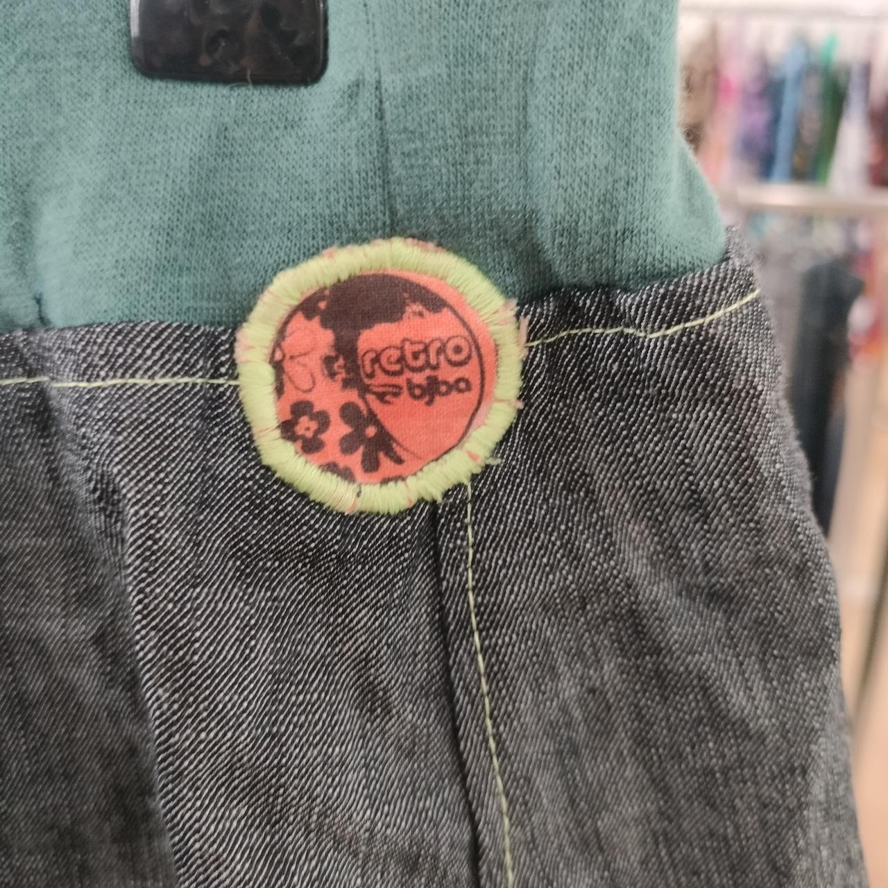 Upcycled denim with green knit waistband and retro floral fabric patch detail, sustainable fashion
