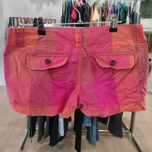 Pink and orange colorblock women's shorts with flap back pockets in a second hand clothing store