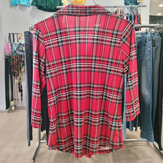 Red plaid long-sleeve shirt on hanger in second hand fashion store