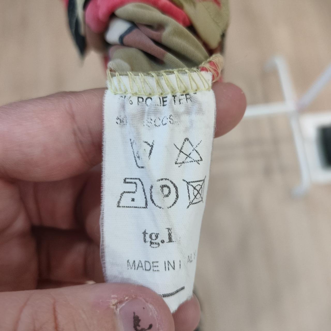 Close-up of a clothing care label with washing symbols and 'Made in Italy' text