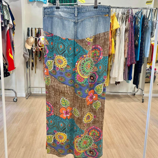 Upcycled denim and floral patchwork maxi skirt hanging in vintage clothing store