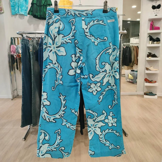 Bright blue floral print pants hanging in a second hand fashion boutique