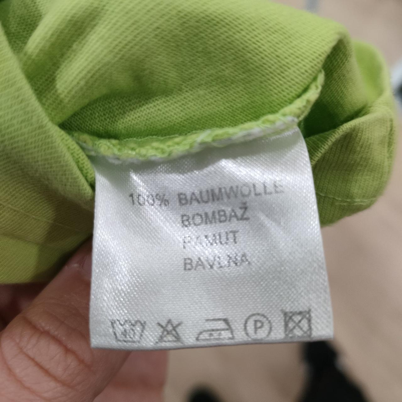 Green cotton garment care label, 100% cotton material, washing symbols visible