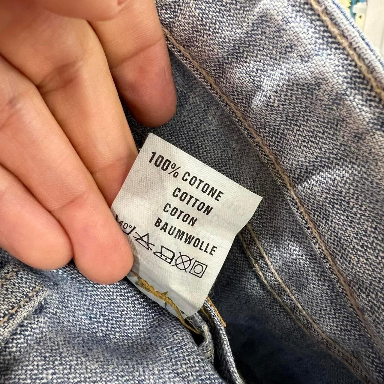 Close-up of 100% cotton jeans care label in denim garment