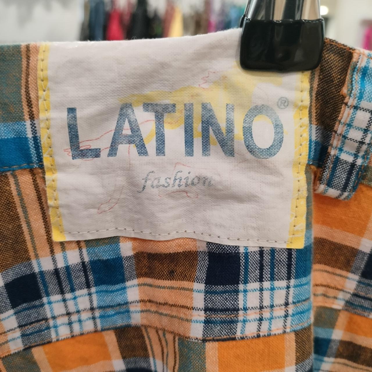 Plaid shirt label with LATINO fashion text, brown, blue, and orange fabric close-up