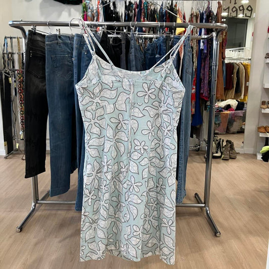 Light blue floral-patterned dress hanging on a rack in a store setting