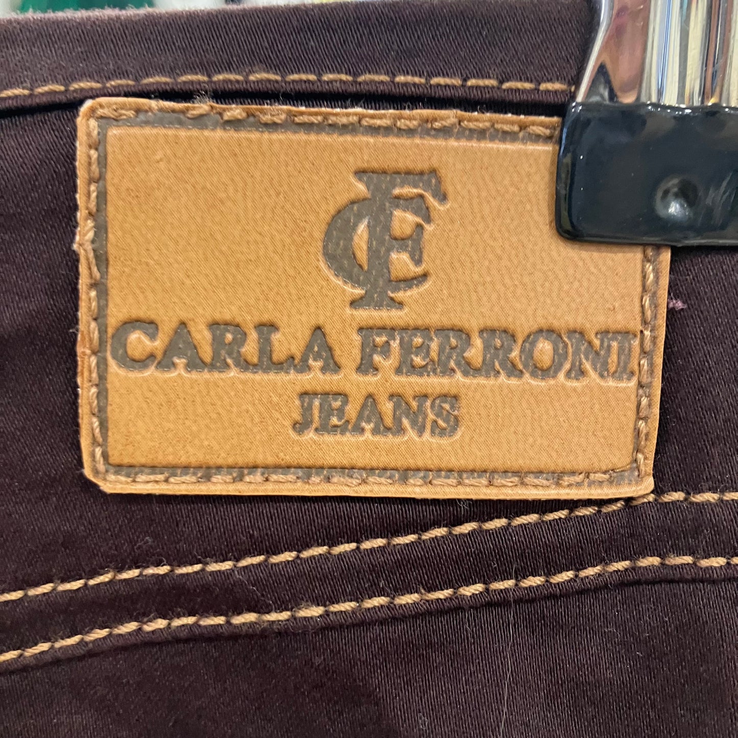 Close-up of Carla Ferroni jeans label on a brown denim fabric