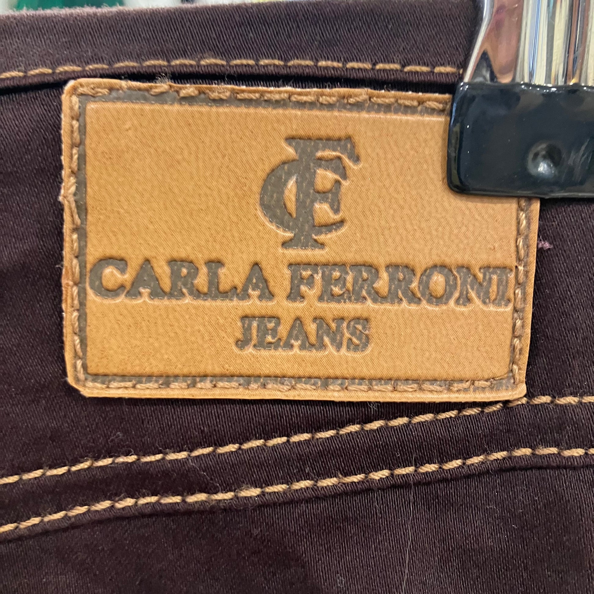 Close-up of Carla Ferroni jeans label on a brown denim fabric