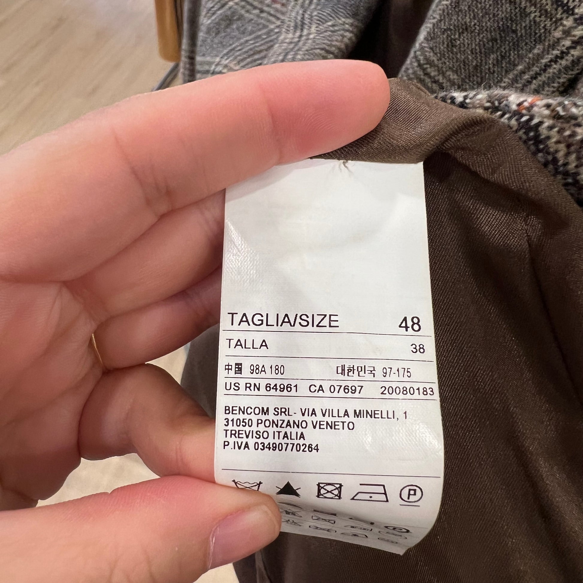 Hand holding a clothing tag with size information