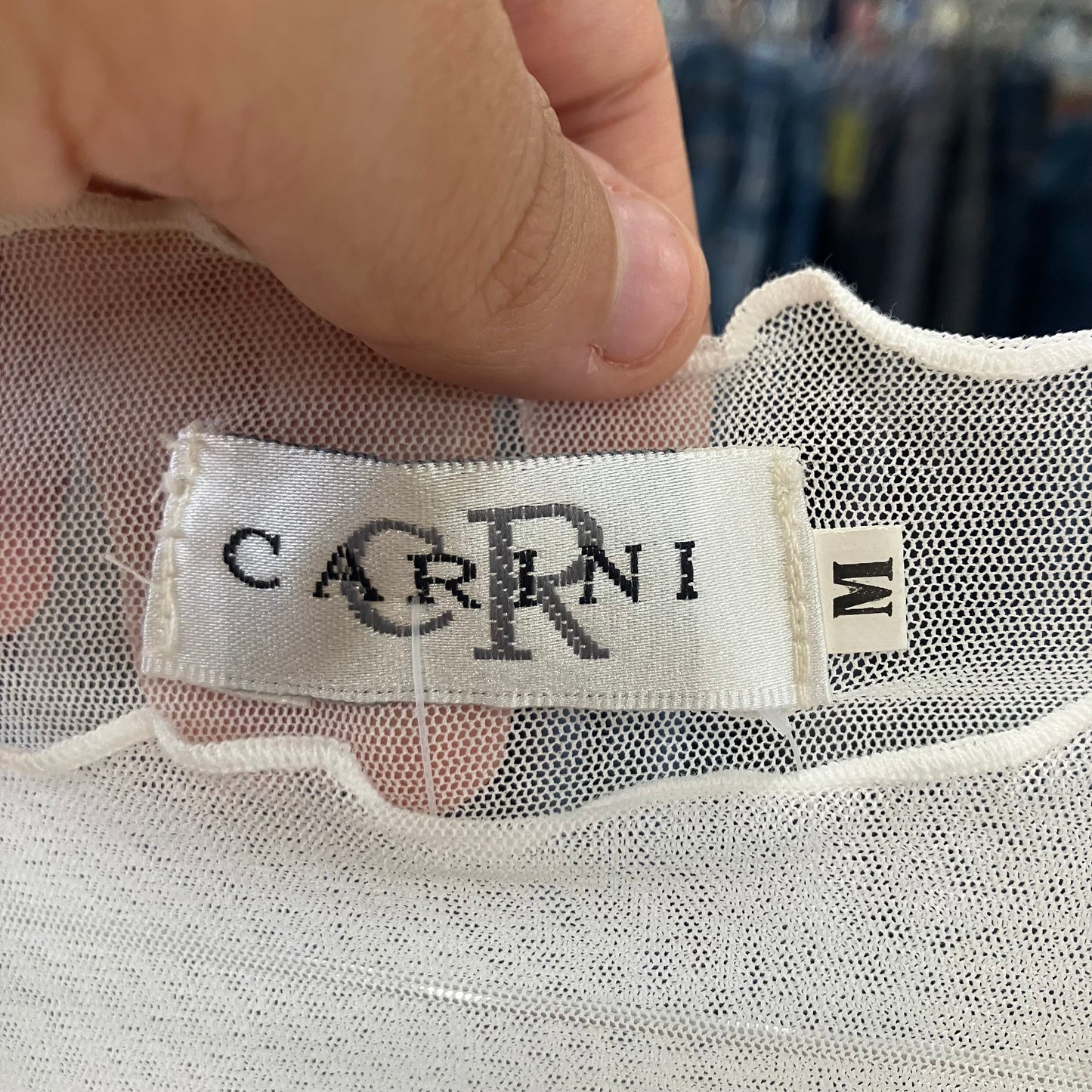 Close-up of a 'CARINI' label on a garment with a blurred background