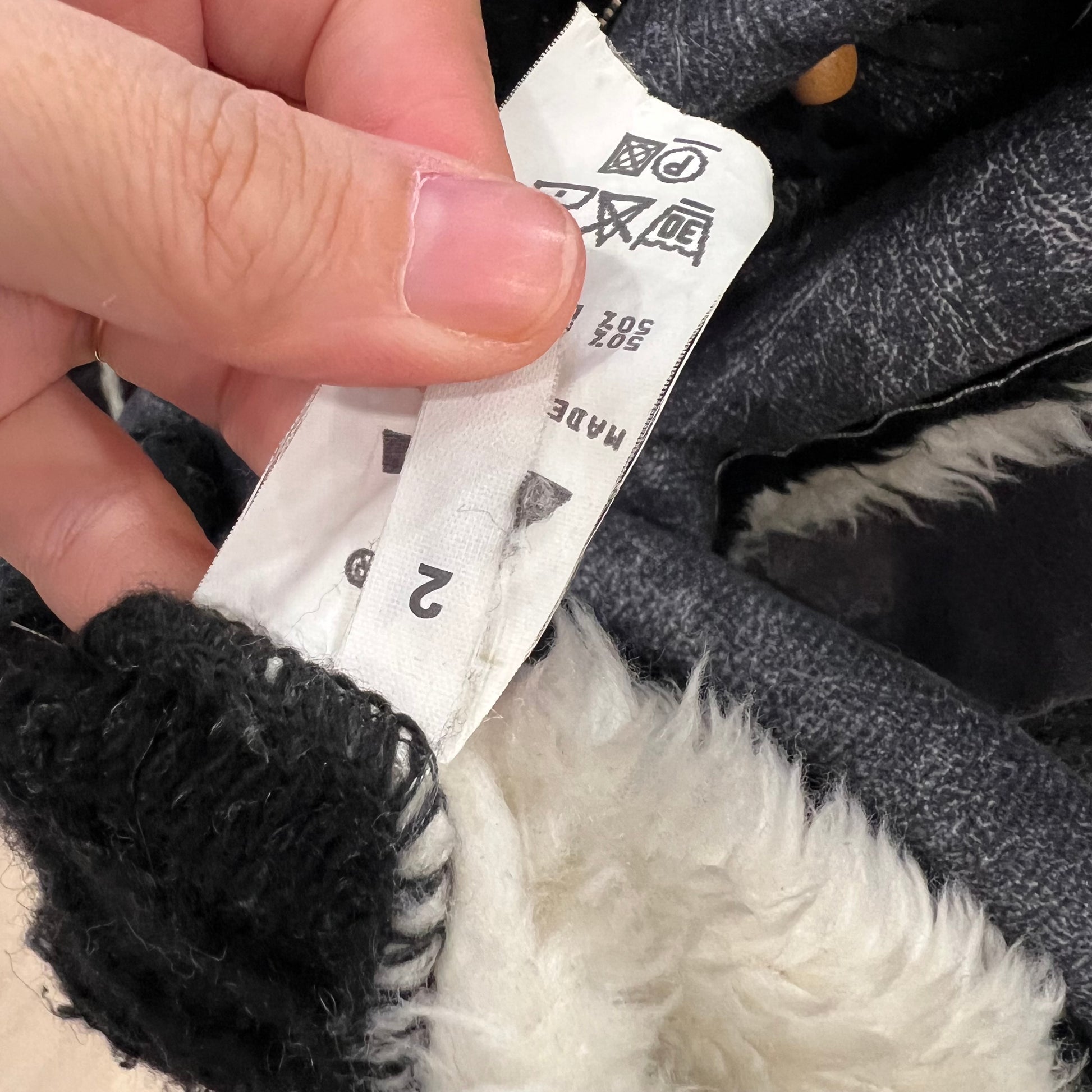 Close-up of a hand holding a label on a product with black and white details