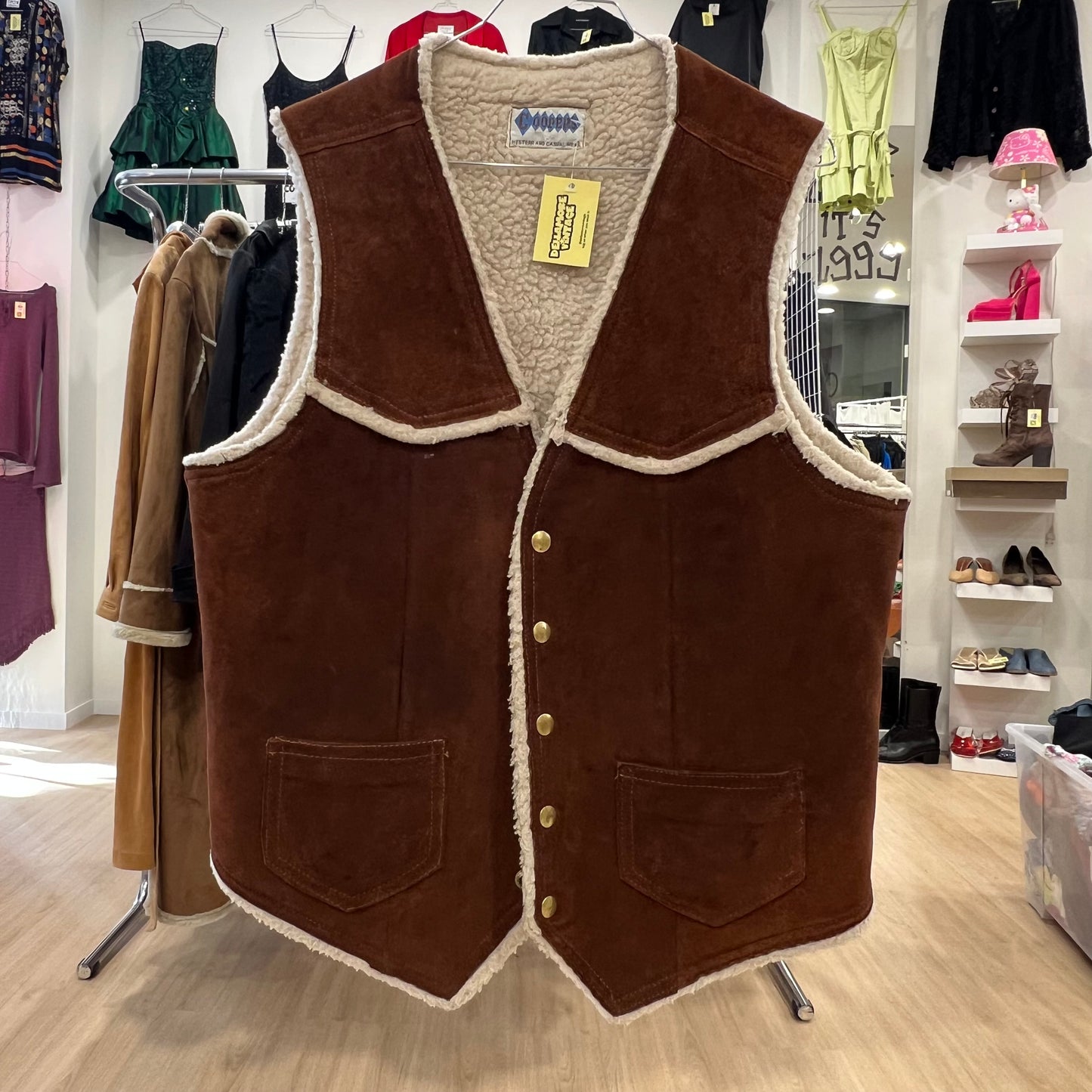 Brown vest with white lining displayed in a store setting