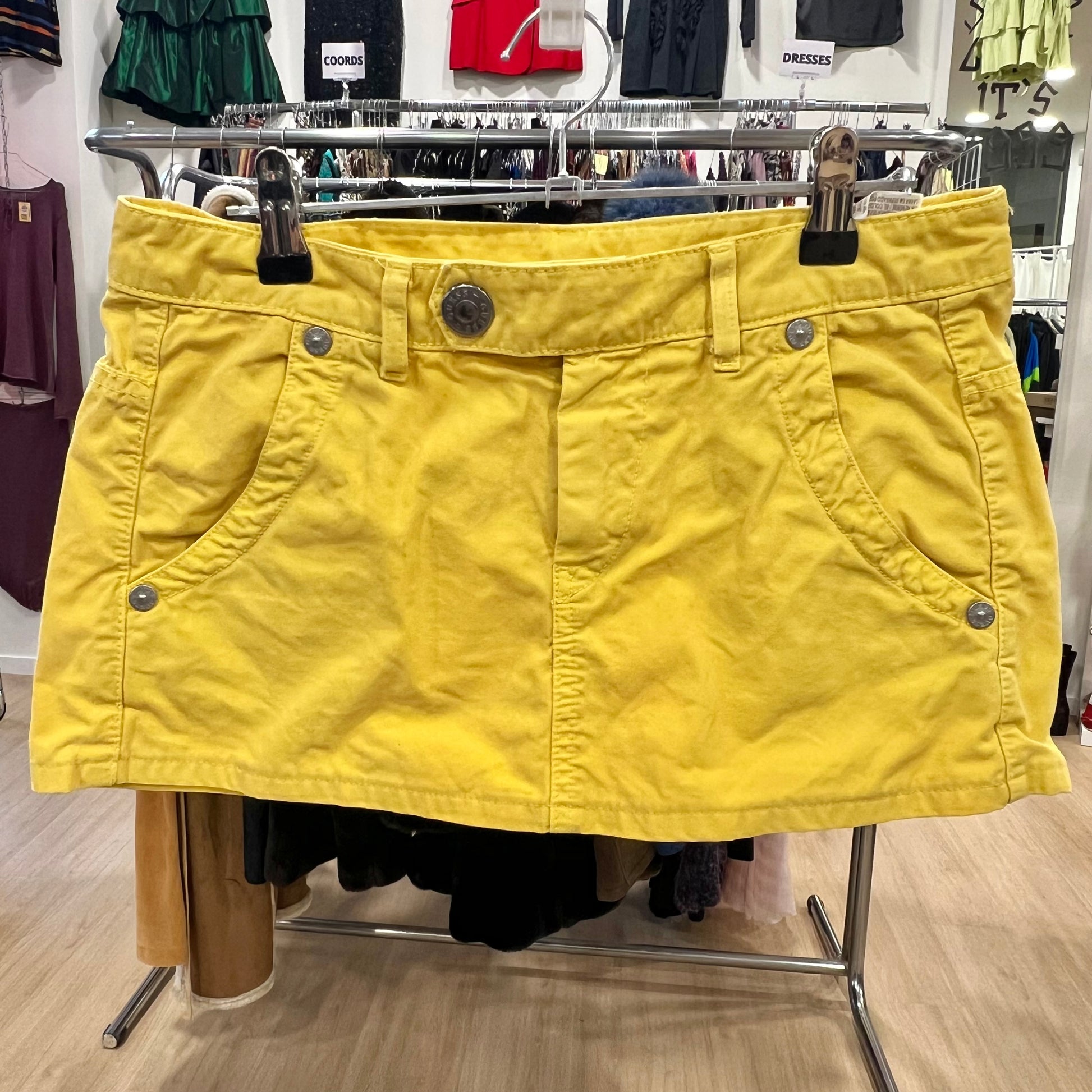 Yellow skirt on a rack in a store setting