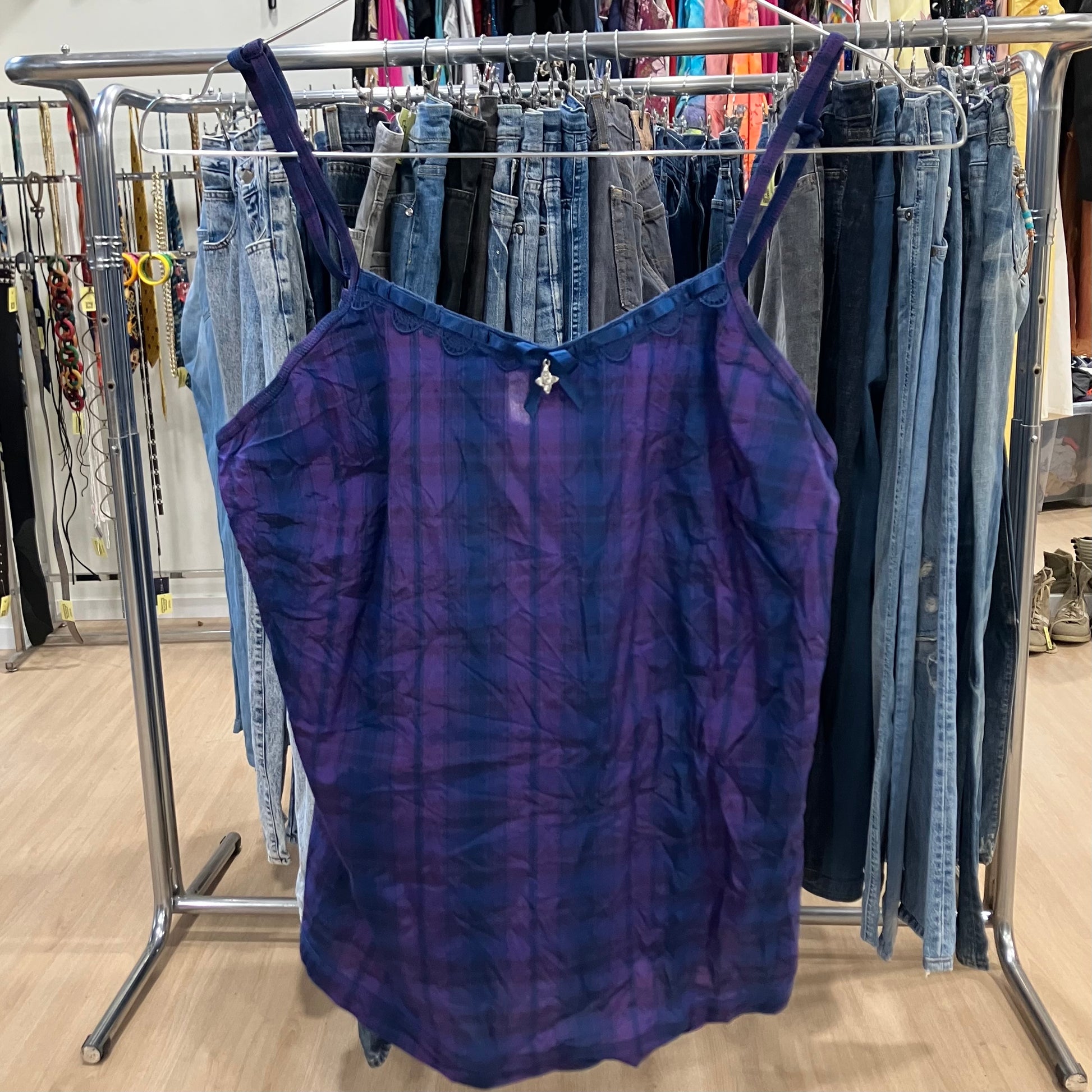 Purple tank top on a clothing rack with jeans in a store setting