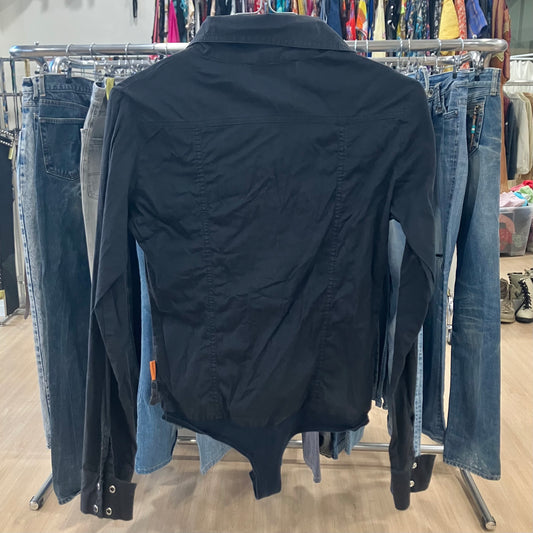 Black shirt on a rack with jeans in a store setting