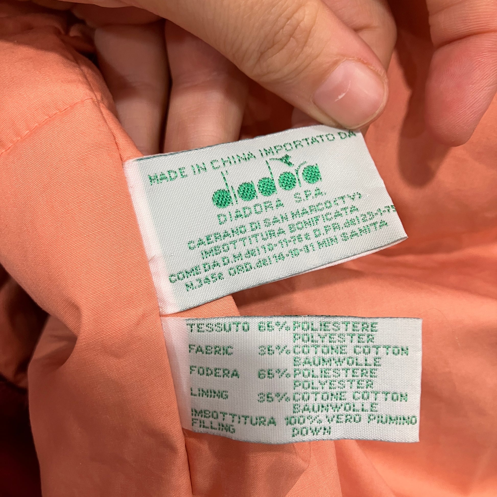 Close-up of Diadora clothing labels on a peach-colored garment