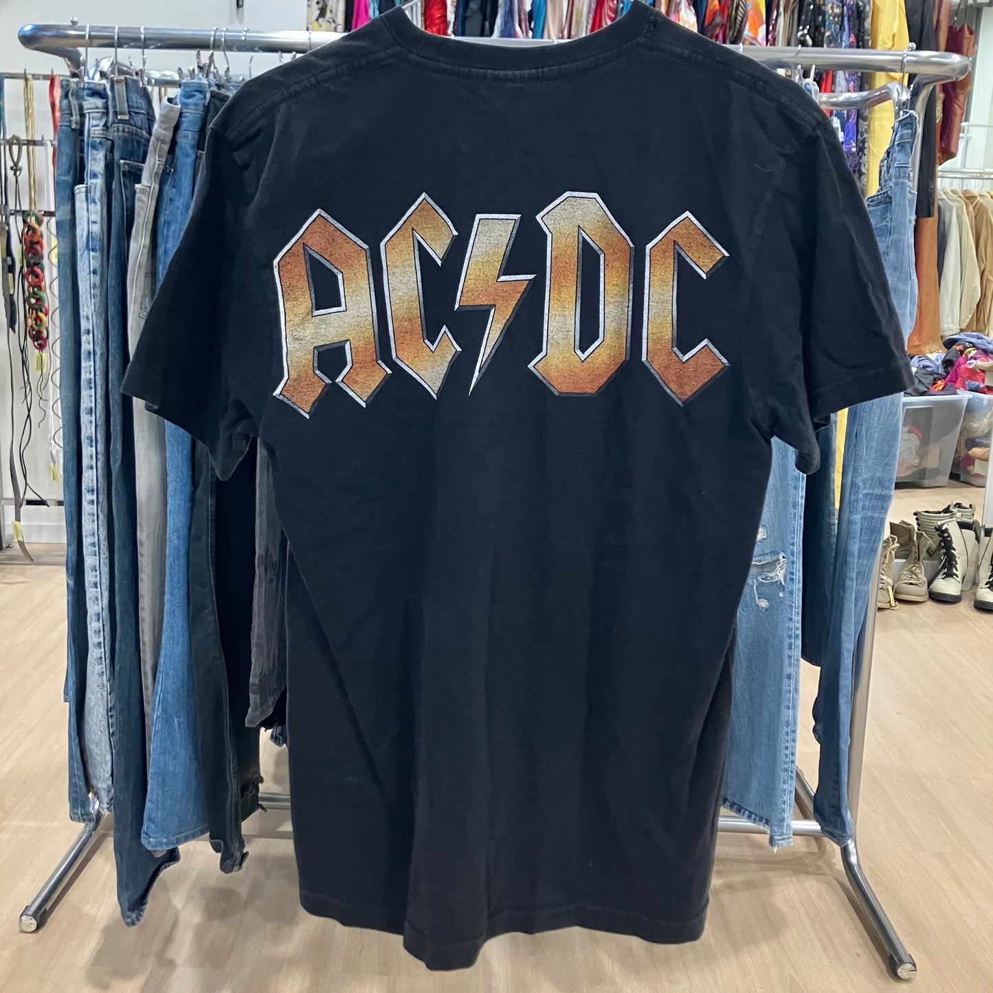 Black t-shirt with AC/DC logo on a clothing rack in a store