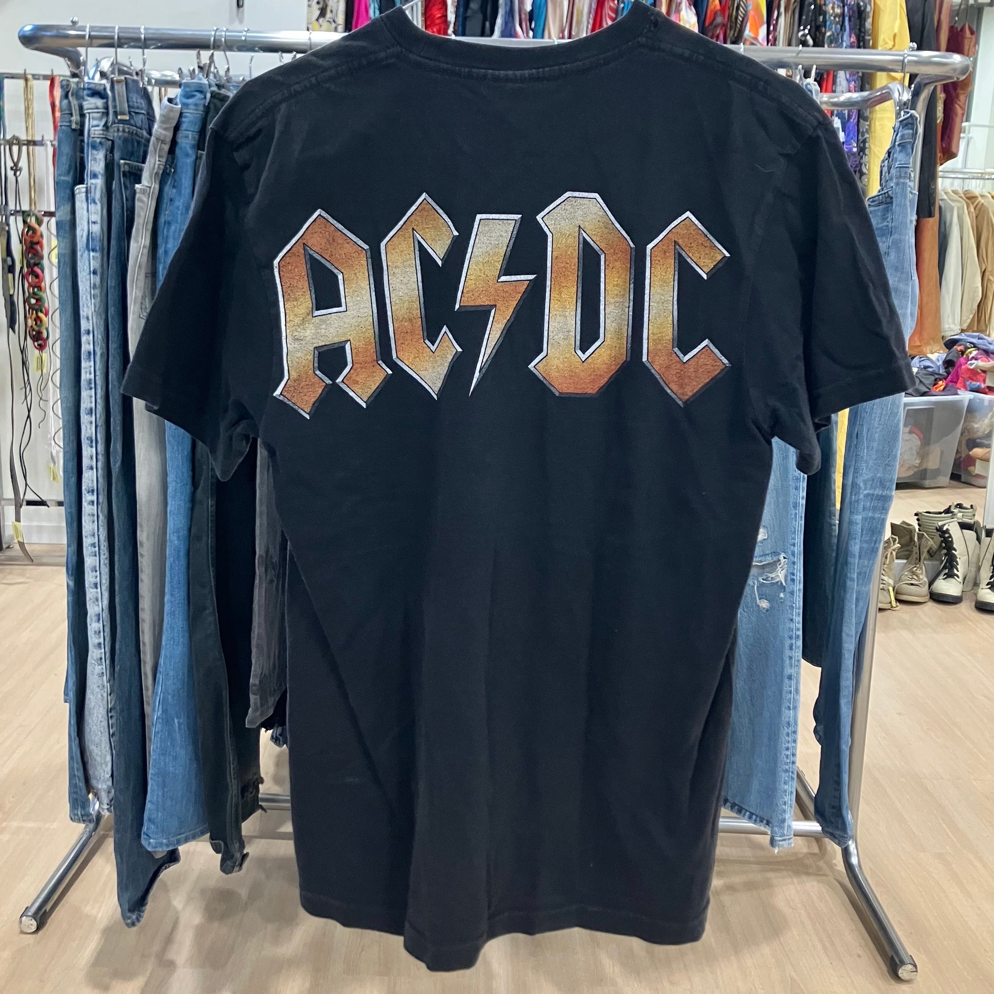 Black t-shirt with AC/DC logo on a clothing rack in a store
