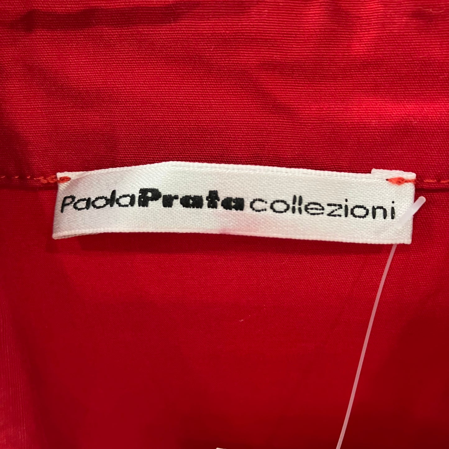 Paola Prata Collezioni label on a red fabric background