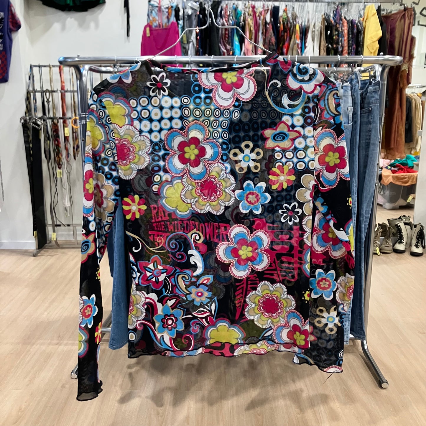 Colorful floral-patterned long-sleeve top on a rack in a store setting