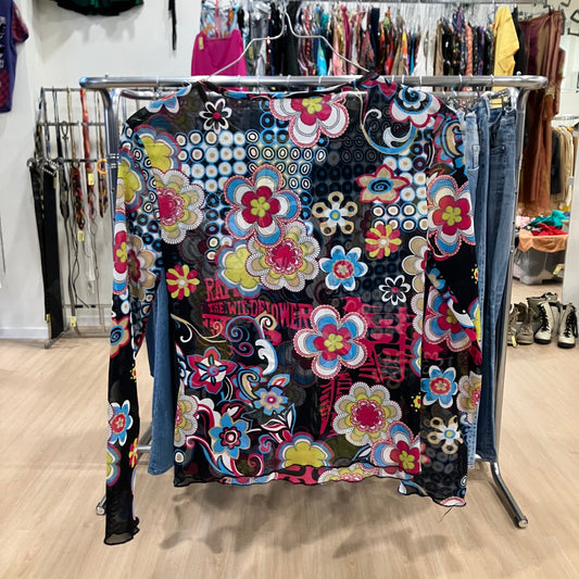 Colorful floral-patterned long-sleeve top on a rack in a store setting