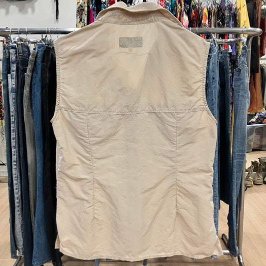 Beige vest on a rack with jeans in a store setting