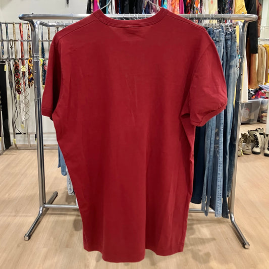 Red t-shirt hanging on a rack in a store setting