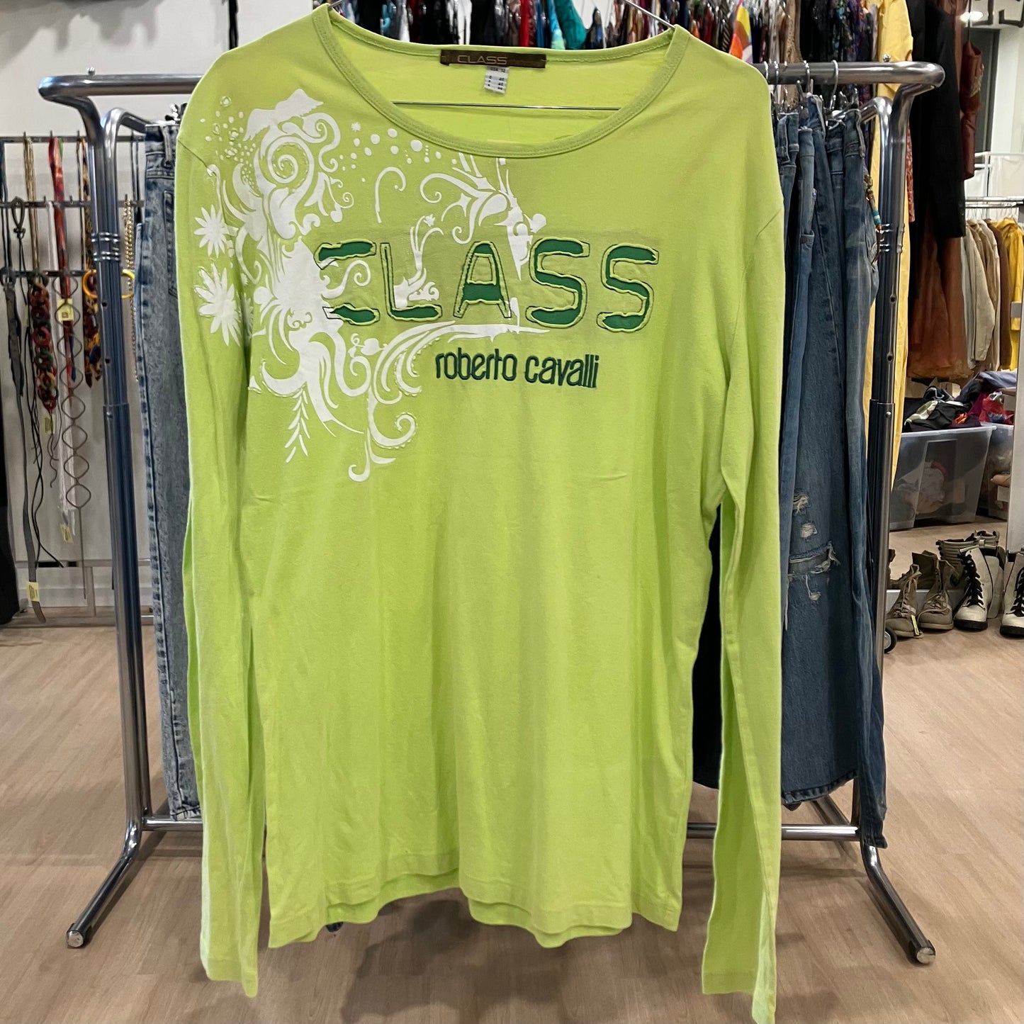 Green long-sleeve shirt with 'Roberto Cavalli' branding on a clothing rack