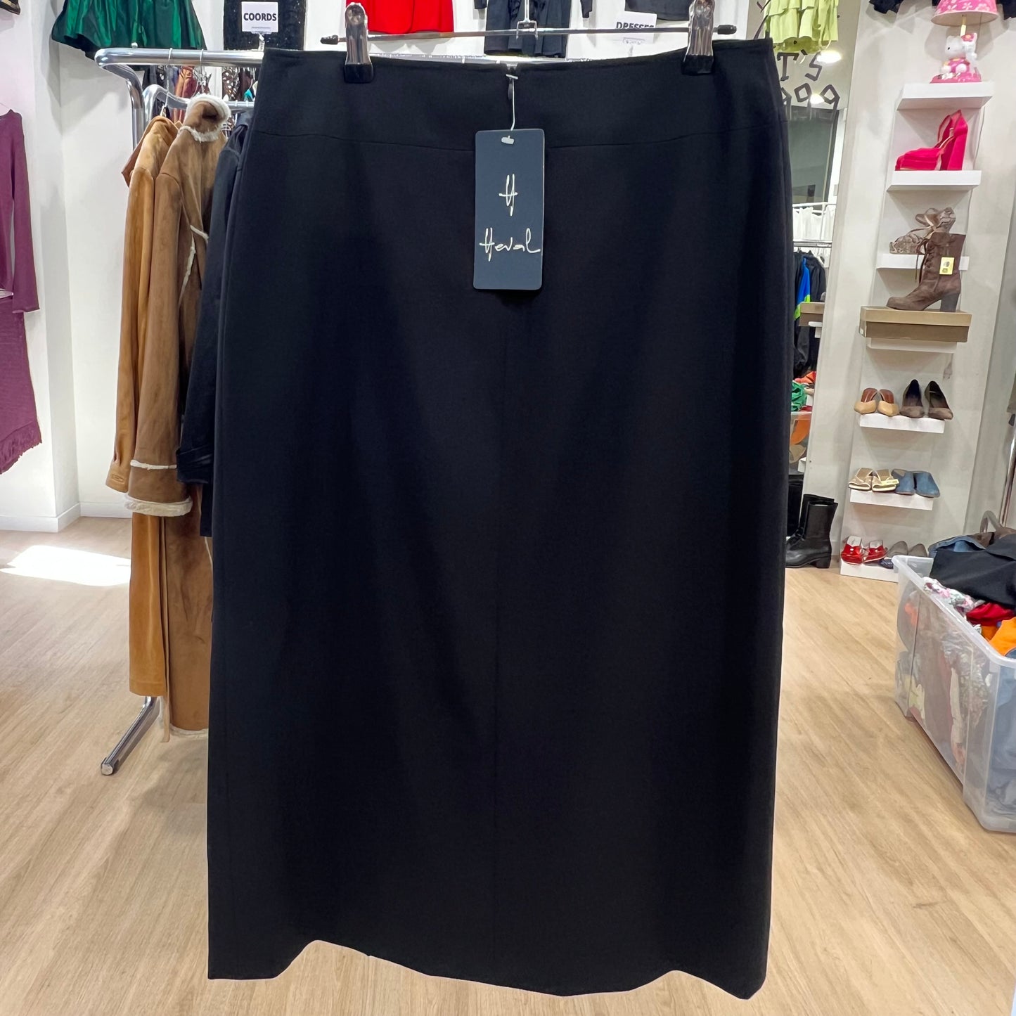 Black skirt with a tag on a rack in a store setting