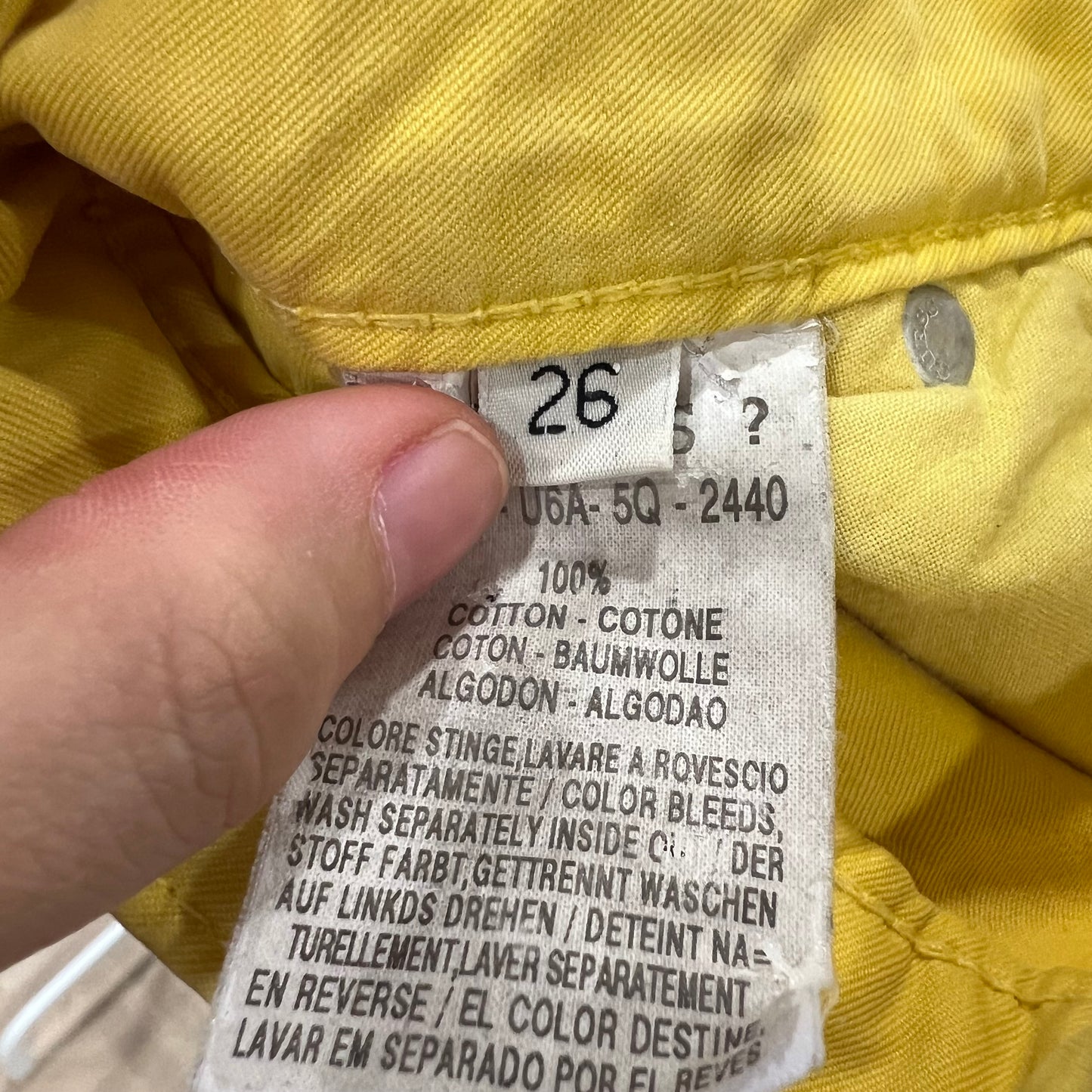 Clothing tag on a yellow garment with text and numbers