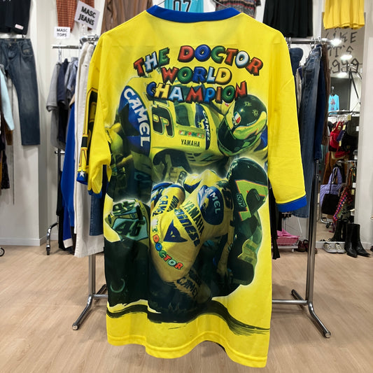 Yellow t-shirt with colorful graphics and text on a rack in a store