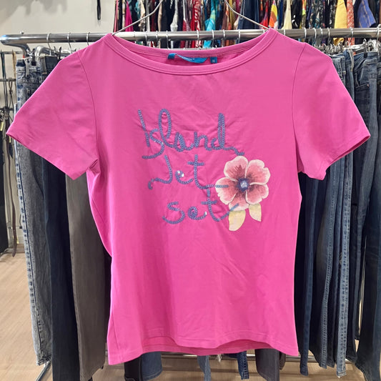 Pink t-shirt with floral design and text on a rack of clothes