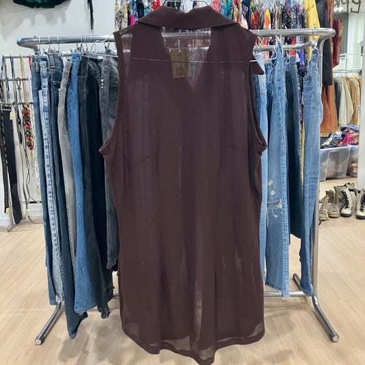 Brown sleeveless dress on a rack with jeans in a store setting