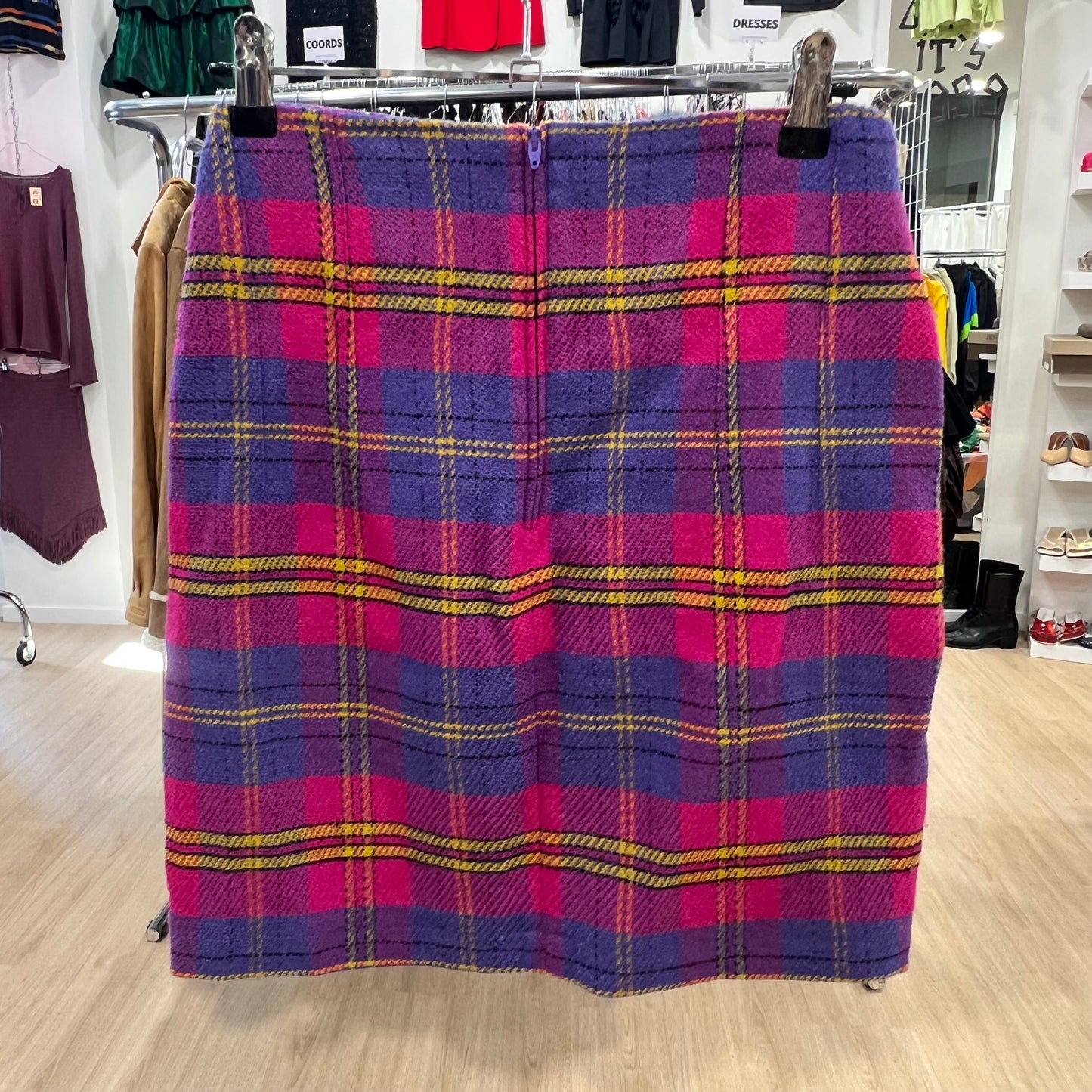 Plaid skirt on a hanger in a store setting