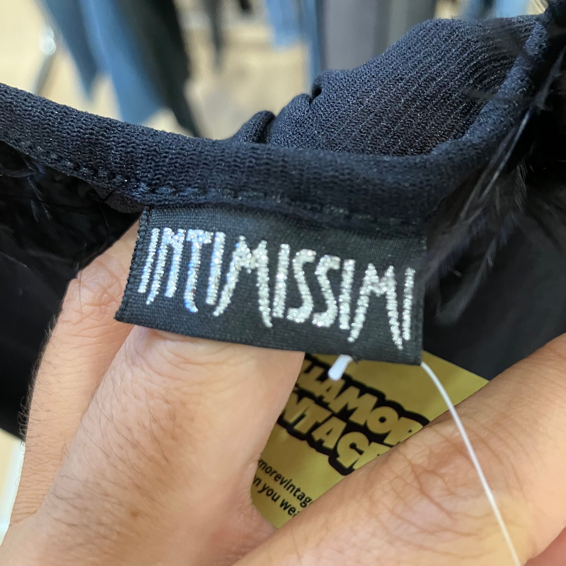 Close-up of a 'INTIMISSIMI' label on black fabric