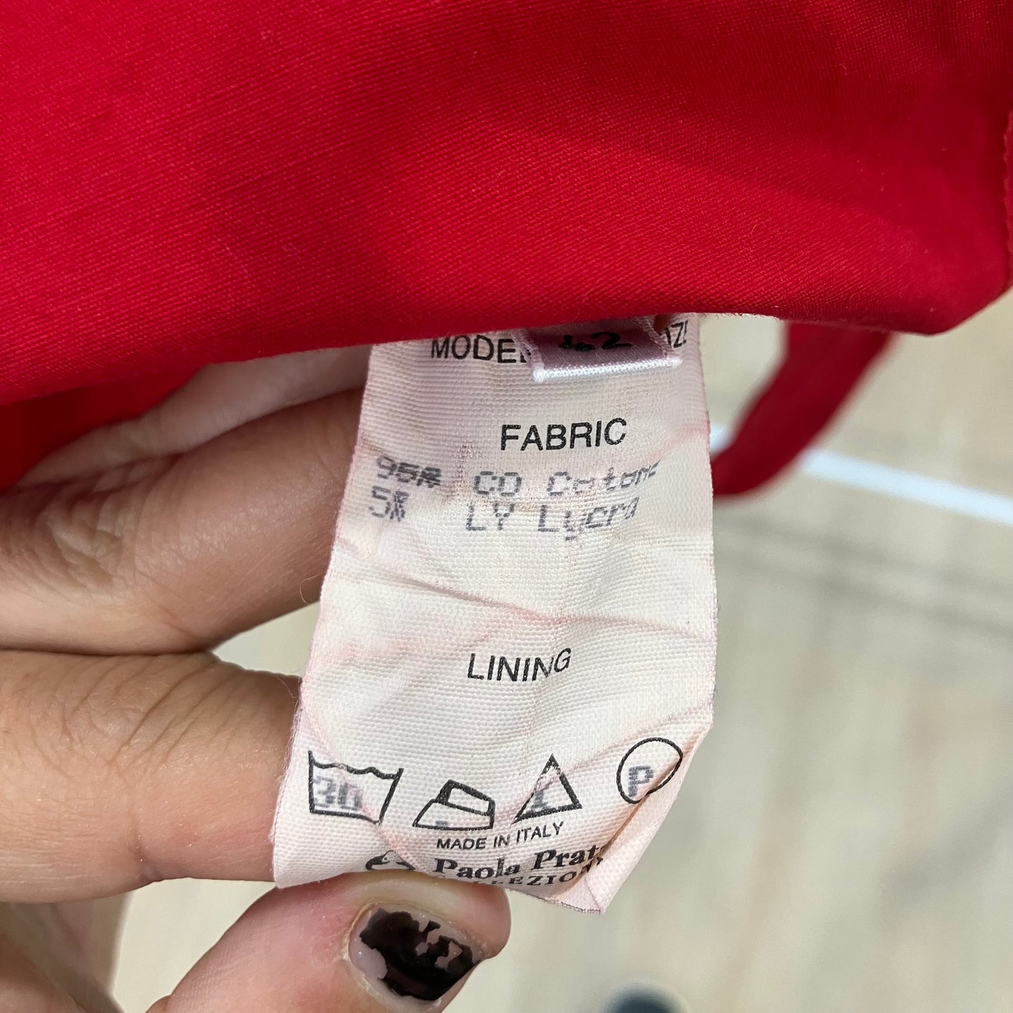 Fabric and lining label on a red garment with a blurred background