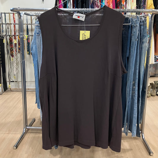 Black sleeveless top on a hanger with a clothing rack in the background