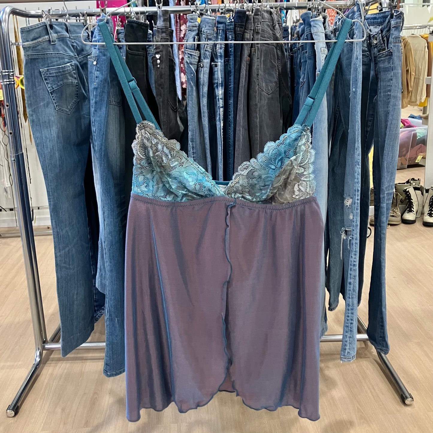 Purple lace-trim slip dress hanging on a rack inside a clothing store