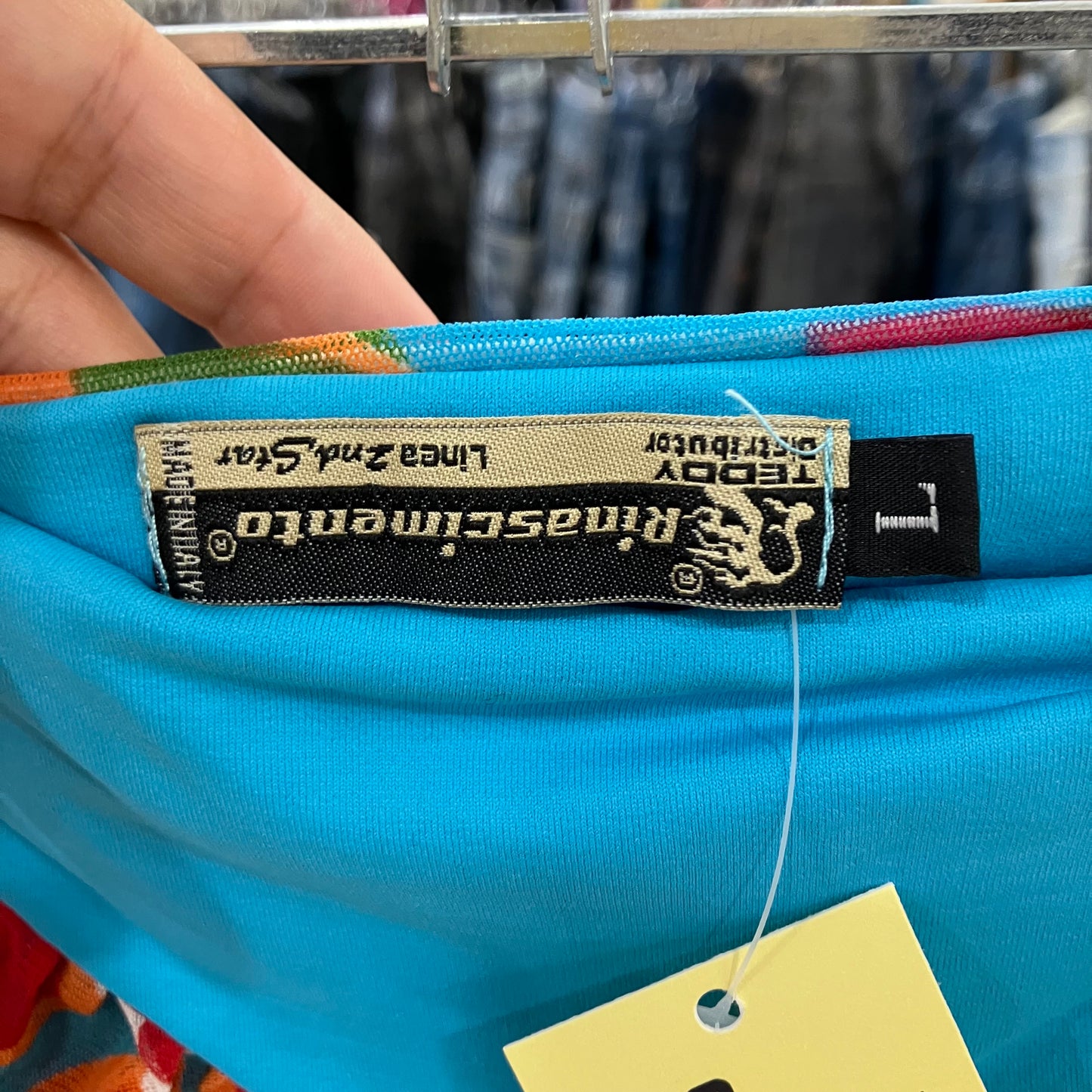 Close-up of a blue garment with a label on a hanger