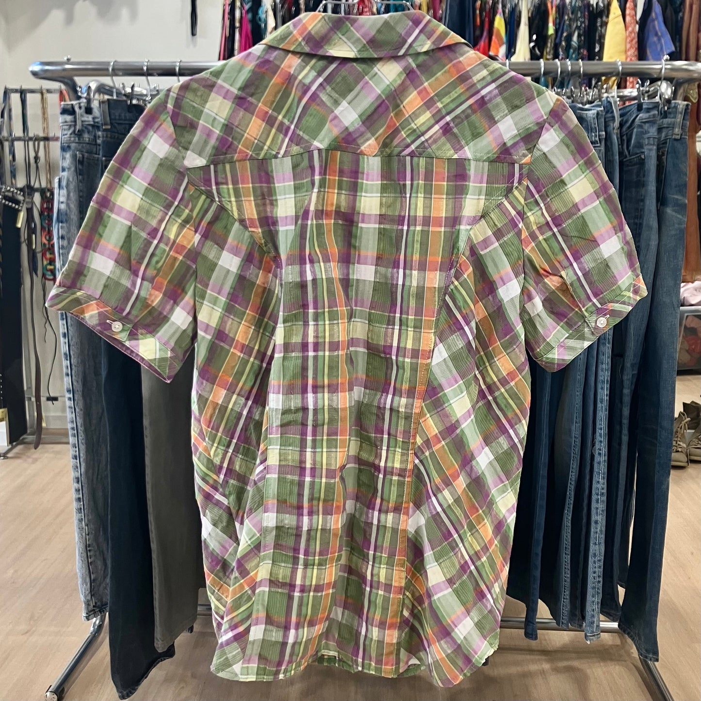 Green plaid shirt on a rack in a store setting