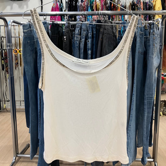 White tank top with a stain hanging on a rack with jeans
