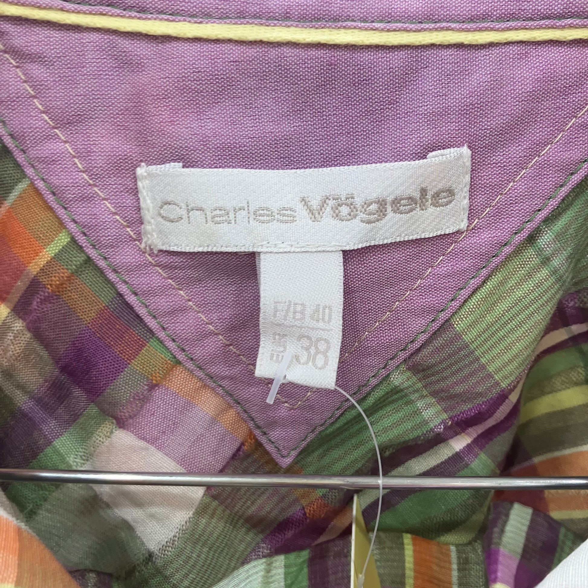 Close-up of a plaid shirt with a Charles Vogele label on a purple background