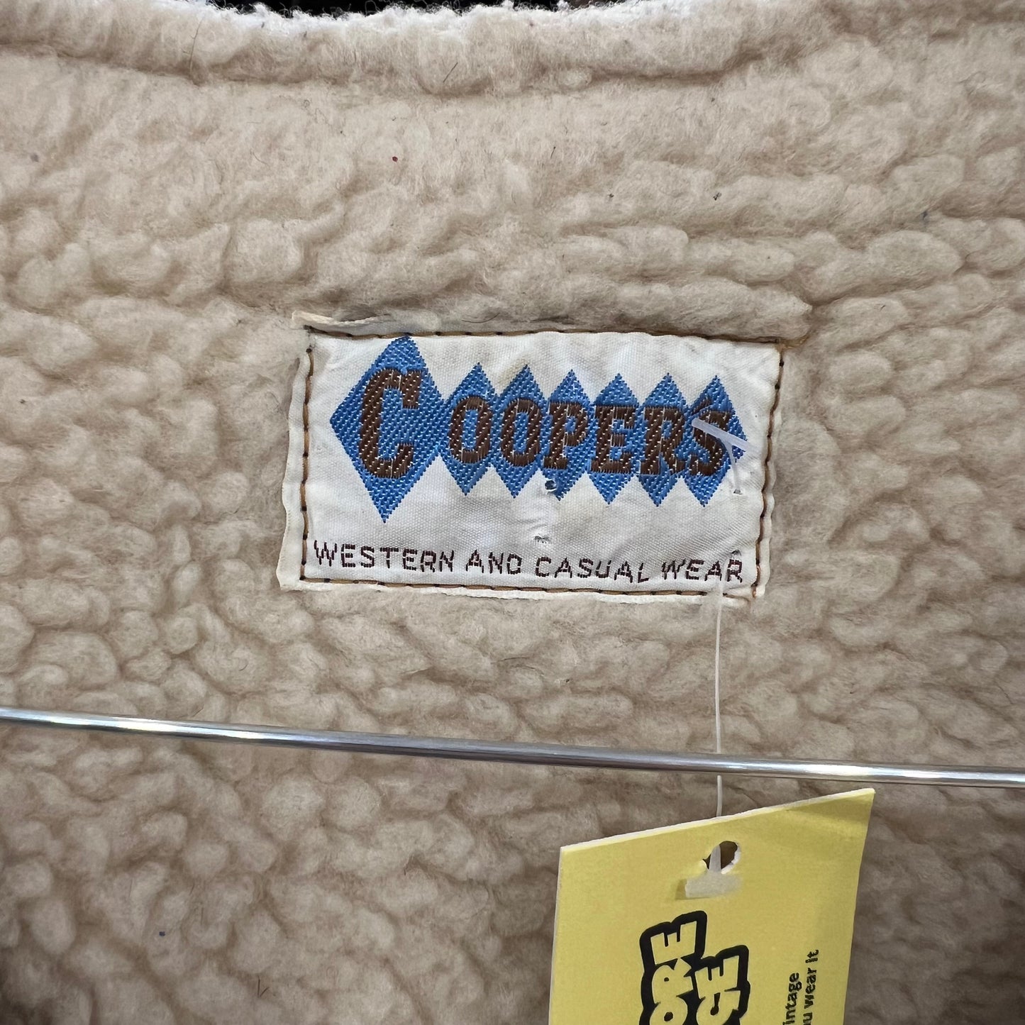 Close-up of a label on a sheepskin fabric surface with 'Coopers' branding